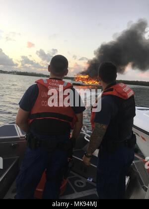 La station de la Garde côtière canadienne Islamorada boatcrew membres observer un navire en feu Tarpon Basin près de Key Largo, en Floride après son arrivée sur scène avec Monroe County Sheriff's Office, et Florida Fish and Wildlife Conservation Commission unités marines, Jeudi, Novembre 30, 2017. Le boatcrew ont aidé à mettre le feu en utilisant l'hélice de leur lavage. Garde côtière des États-Unis avec la permission de la station de la Garde côtière canadienne Islamorada Banque D'Images