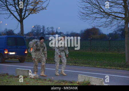 Deux soldats du 39e Bataillon des transmissions stratégiques participer à un ruck pour la reconnaissance, un trois-mile road mars sur la base aérienne de Chièvres, Belgique, le 20 novembre, 2017. Les soldats ont défilé avec leurs sacs ruck, contenant de plus de 70 livres d'aliments en conserve et des aliments non périssables, de donner les éléments à un orphelinat local. (U.S. Photo de l'armée par Visual Spécialiste de l'information Henri Cambier) Banque D'Images