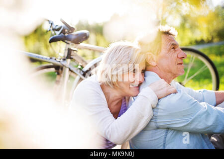 Beau couple avec des bicyclettes à l'extérieur au printemps la nature. Banque D'Images