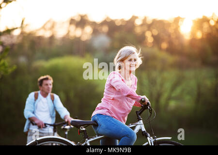 Beau couple avec des bicyclettes à l'extérieur au printemps la nature. Banque D'Images