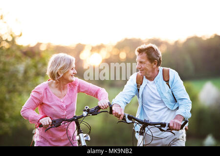 Beau couple avec des bicyclettes à l'extérieur au printemps la nature. Banque D'Images