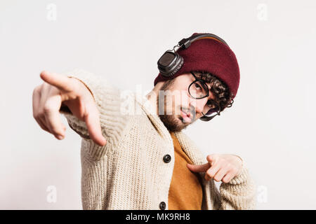 Portrait d'un jeune homme avec un chapeau et un casque de studio. Banque D'Images