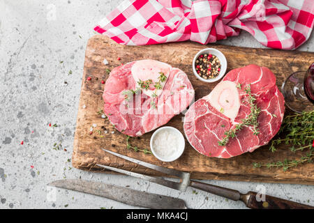 Tranches de jarret de veau fraîche Viande de boeuf pour Osso Buco la cuisson sur une planche à découper avec des ingrédients et assaisonnements le thym, poivre, sel. Banque D'Images