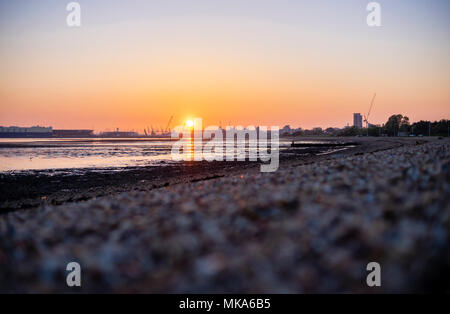 Coucher de soleil sur les quais de Southampton à marée basse, vue de Weston Shore, Hampshire, England, UK Banque D'Images