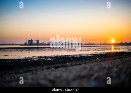 Coucher de soleil sur les quais de Southampton à marée basse, vue de Weston Shore, Hampshire, England, UK Banque D'Images
