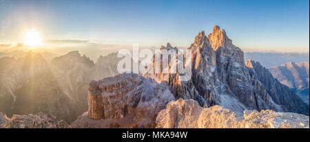 Belle vue de célèbres Tre Cime di Lavaredo sommets de montagne dans la chaîne de montagnes des Dolomites illuminée en jolie lumière du soir au coucher du soleil d'or Banque D'Images
