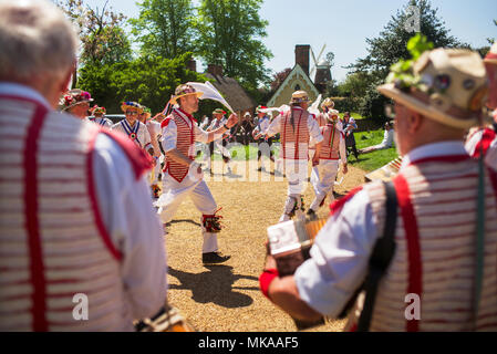 Thaxted Essex England UK. Banque de jours de mai Maison de vacances lundi 7 mai 2018 sur l'un des plus chauds peuvent jour lundis fériés jamais enregistré la Thaxted Morris à rayures rouges et blanches et les Blackmore Morris en bleu du côté de la danse dans la région de Chelmsford Bull Ring en face de Thaxted Église et les maisons l'Aumône Thaxted pour célébrer les vacances de mai. Crédit : BRIAN HARRIS/Alamy Live News Banque D'Images