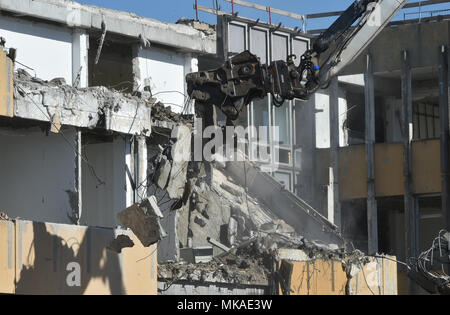 07 mai 2018, l'Allemagne, Potsdam : Une Pelle de démolition qui travaillent sur la façade extérieure du bâtiment du collège technique dans le Vieux Marché. Les travaux de démolition doivent être terminé d'ici l'été 2018 et le démantèlement total de l'ordre qui doit être terminé d'ici l'automne. Photo : Bernd Settnik/dpa-Zentralbild/dpa Banque D'Images