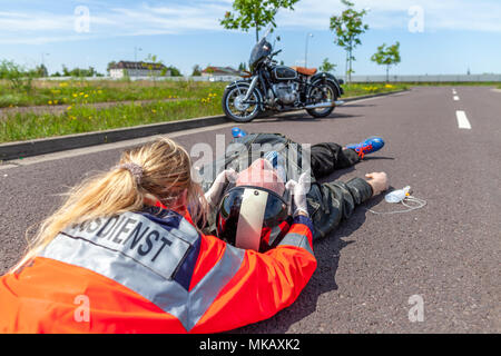 Un ambulancier allemand supprime un casque d'un blessé. Rettungsdienst est le mot allemand pour les services d'ambulance. Banque D'Images