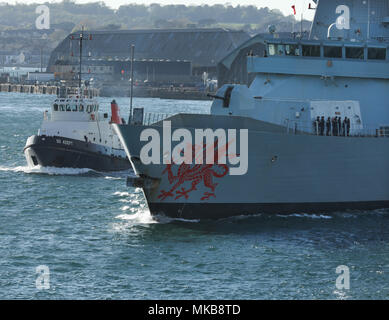 Le Type 45 destroyer HMS Dragon quitter Plymouth accompagné par le remorqueur Adept Banque D'Images