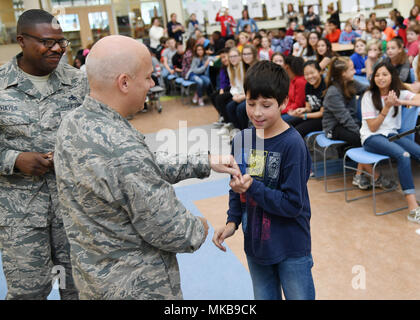 Le colonel Roman Hund, commandant de l'installation, présente un pin à Asher Schultz, une cinquième année à Hanscom Middle School, au cours d'une assemblée générale à l'école le 17 novembre, en tant que chef Master Sgt. Henry Hayes, chef du commandement de l'Hanscom, regarde. Hund et Hayes étaient sur place afin de présenter les prix d'environ 50 élèves de l'école. (U.S. Air Force photo par Linda Labonté Britt) Banque D'Images