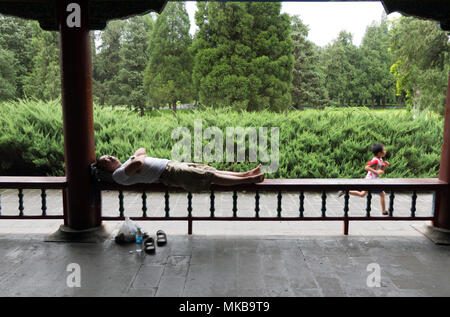 Homme chinois prenant une sieste dans le parc près du Temple du ciel, célèbre attraction touristique à Beijing, Chine, Asie Banque D'Images