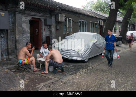 Des jeux de cartes les hommes chinois à Beijing, Chine, Asie. Les amis s'amusant avec des activités de loisirs dans un hutong (ancienne rue étroite) Banque D'Images