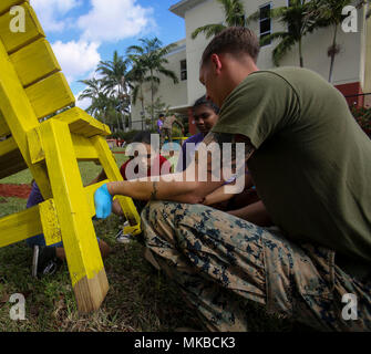 Le Caporal des Marines américain Jacob Cummings, un chef d'équipe incendie avec 2e Blindés de reconnaissance, aide les élèves à l'école intermédiaire des sous-Bois peinture un banc pendant la Semaine de la flotte du Port Everglades, le 3 mai 2018. Au cours de la Semaine de la flotte, les Marines et les marins sont consacrés à soutenir les collectivités et à fournir de l'aide humanitaire ainsi que leurs capacités de combat au public. (U.S. Marine Corps photo par Lance Cpl. Samuel Lyden) Banque D'Images