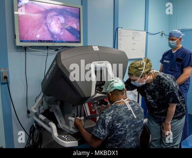 180504-N-RM689-0300 Trincomalee, Sri Lanka (4 mai 2018) Le Cmdr. Tamara Worlton (à droite), un chirurgien militaire affecté au Commandement maritime navire-hôpital USNS Mercy (T-AH 19) pour le Partenariat du Pacifique 2018 (PP18) et le Dr Vyramuthu Varanitharan (à gauche), un chirurgien général sri-lankais à Base Hospital Mutur, sri-lankais de l'hôpital de Base de Mutur, discuter des techniques de chirurgie robotique au cours de la première chirurgie assistée par robot sur un patient alors qu'à bord de la miséricorde en utilisant le robot da Vinci Surgical System XI. PP18's mission est de travailler ensemble avec l'hôte et les pays partenaires à améliorer l'interopérabilité régionale et Banque D'Images