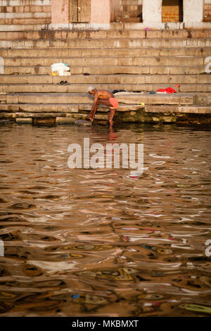 Un monsieur âgé a un matin tôt se laver dans le Gange à Varanasi. Les hindous croient que le bain dans le fleuve sacré efface les péchés. Banque D'Images