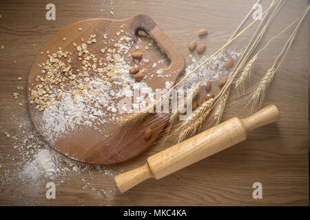 Équipement de fabrication de gâteau. sol en bois rouleau à pâtisserie en bois brun et divers sur la table. Banque D'Images