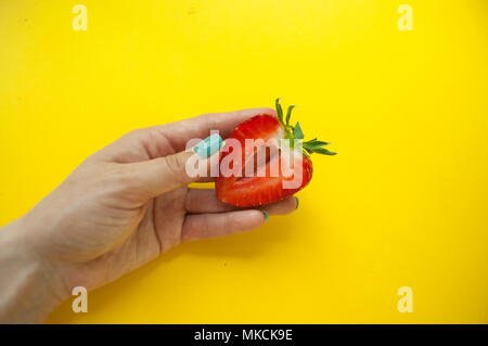 Une fraise dans les mains de la vierge. Banque D'Images