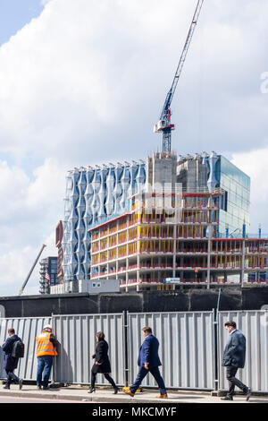 Les gens en passant devant le panneau publicitaire site de construction à neuf Elms avec construction de nouvelle ambassade américaine en arrière-plan. Banque D'Images