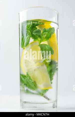 Frais Frais infusé avec de l'eau Detox bio Menthe citrons mûrs en tranches en grand verre givré. Arrière-plan blanc. Rafraîchissement d'été Detox boisson saine. Co Banque D'Images