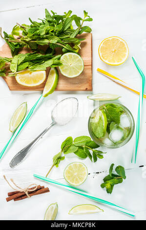 Ingrédients pour faire les mojitos - feuilles de menthe, de sucre et de citron vert sur fond blanc Banque D'Images