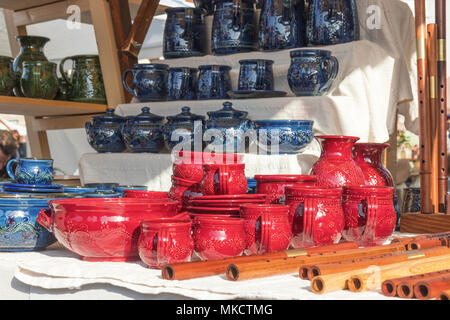 Tasses en céramique et de casseroles, sifflets en bois, instruments de musique en bois, de la rue du marché, des biens affichés sur la table. Banque D'Images