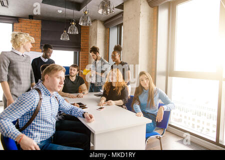 Les étudiants multiculturel groupe activiste formant en consultation dans l'immeuble de bureaux loft Banque D'Images