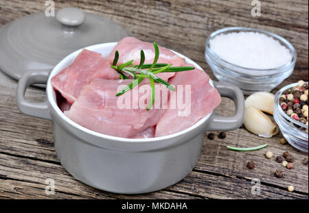 Close up de matières de la viande fraîche en morceaux dans une casserole sur la vieille table Banque D'Images