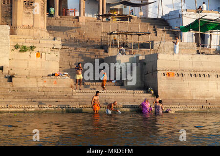 Une famille hindoue laver leurs péchés dans le Gange tandis que d'autres offrent des prières à leurs dieux des Ghats de Varanasi. Banque D'Images