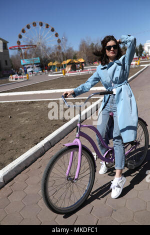 Jeune femme élégante d'une bicyclette. Banque D'Images