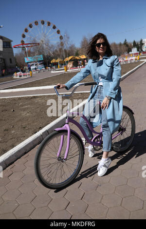 Jeune femme élégante d'une bicyclette. Banque D'Images