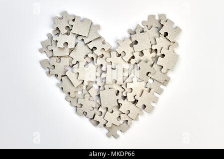 Coeur fait à partir de casse-tête. Forme de coeur fait de puzzles morceaux sur fond blanc. Banque D'Images