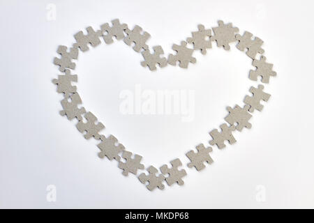 Coeur cadre en puzzles. La forme de coeur de Jigsaw puzzles sur fond blanc. Happy Valentines Day. Banque D'Images