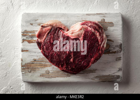 Le persillage Ribeye Steak sur plaque de bois Banque D'Images