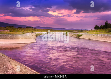 Ciel coucher de soleil spectaculaire et coloré avec la couleur magenta orange et bleu nuages sur soft, reflétant la lumière du soleil et de la rivière rivière Banque D'Images