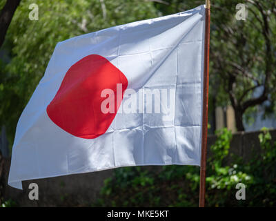 Terre japonais du soleil levant drapeaux dans le vent Banque D'Images