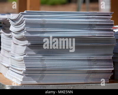 Pile de périodiques agrafés assis dans une pile sur une table en plein air Banque D'Images