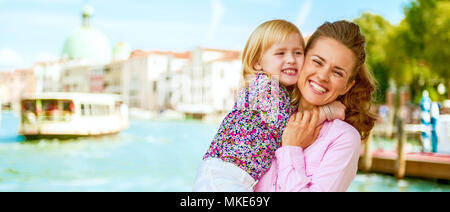 Happy mother and baby hugging sur grand canal embankment à Venise, Italie Banque D'Images