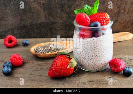 Berry sain chia pudding en pots. Scène avec un fond sombre. Banque D'Images