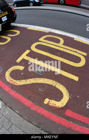 Les zones de contrôle de circulation du centre-ville avec arrêt en jaune avec des lignes rouges sur le tarmac rouge Banque D'Images