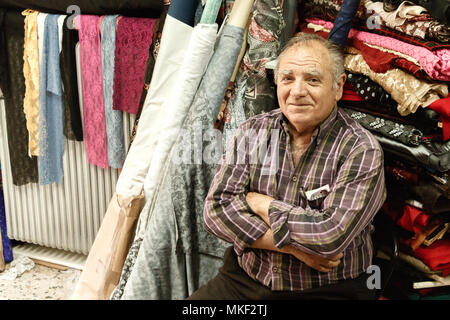 Larissa, Thessalie, Grèce - Mai 4th, 2018 : Portrait of a senior man sitting dans son tissu boutique situé dans la ville de Larissa, en Grèce. Banque D'Images