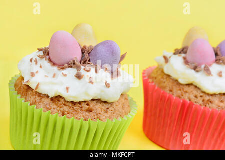 Close up of cupcakes avec des œufs en chocolat sur fond jaune Banque D'Images