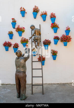 La sculpture, l'homme figure pendaison de pots à fleurs, œuvre d'art, Cordoue, Andalousie, Espagne Banque D'Images
