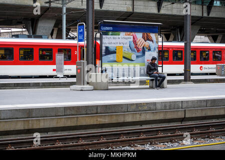 Homme attendant le train pour arriver à la gare principale de Lucerne, Lucerne, Suisse, Europe Banque D'Images