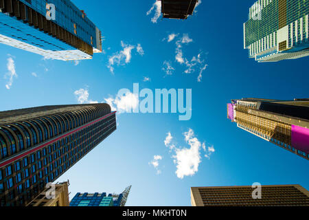 Vue depuis le bas vers le haut de certains des gratte-ciel de Manhattan, ciel bleu et nuages blancs à l'arrière-plan. New York City, USA. Banque D'Images