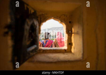 Deux filles indiennes portant la robe traditionnelle indienne "aree' sont à admirer le paysage de Jaipur. Photo prise à partir d'une petite fenêtre sur le Hawa Mahal Banque D'Images