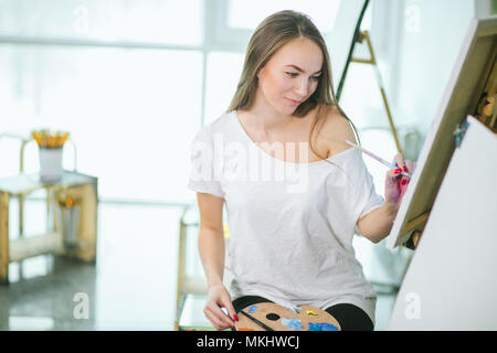 Temps pour la création. Jeune femme faisant appel à l'aide de peinture au chevalet leçon d'art Banque D'Images