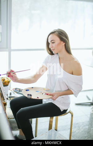 Temps pour la création. Peinture et attrayants caucasian woman posing in profile in studio Banque D'Images