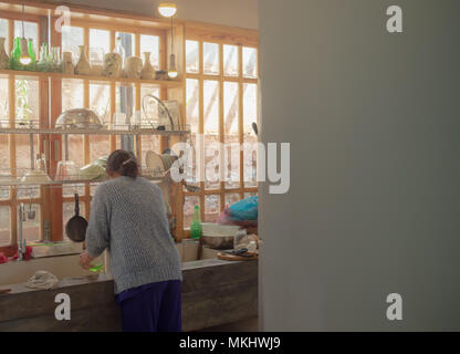 Femme lave-vaisselle dans l'évier de la cuisine où l'espace mural dans la cuisine simple à la Chambre Banque D'Images