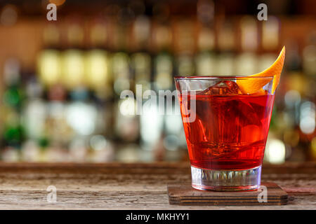 Negroni cocktail dans une discothèque sur un comptoir de bar en bois miteux. Cocktail avec gin, campari et martini rosso Banque D'Images